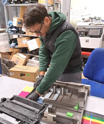 Francesco, tecnico PTS che sta riparando una stampante multifunzione di un'azienda cliente